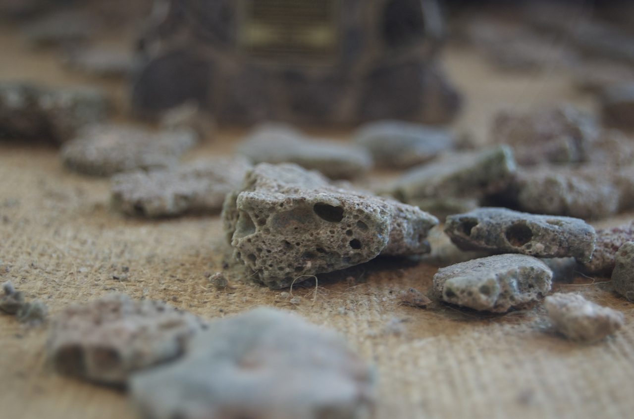 A close-up photograph of trinitite, the glassy crust of fused sand produced by the first nuclear detonation