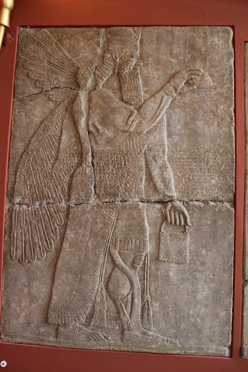 An alabaster bas-relief of a winged Apkallu holding a bucket and a cone, from the Northwest Palace of Ashurnasirpal II at Nimrud