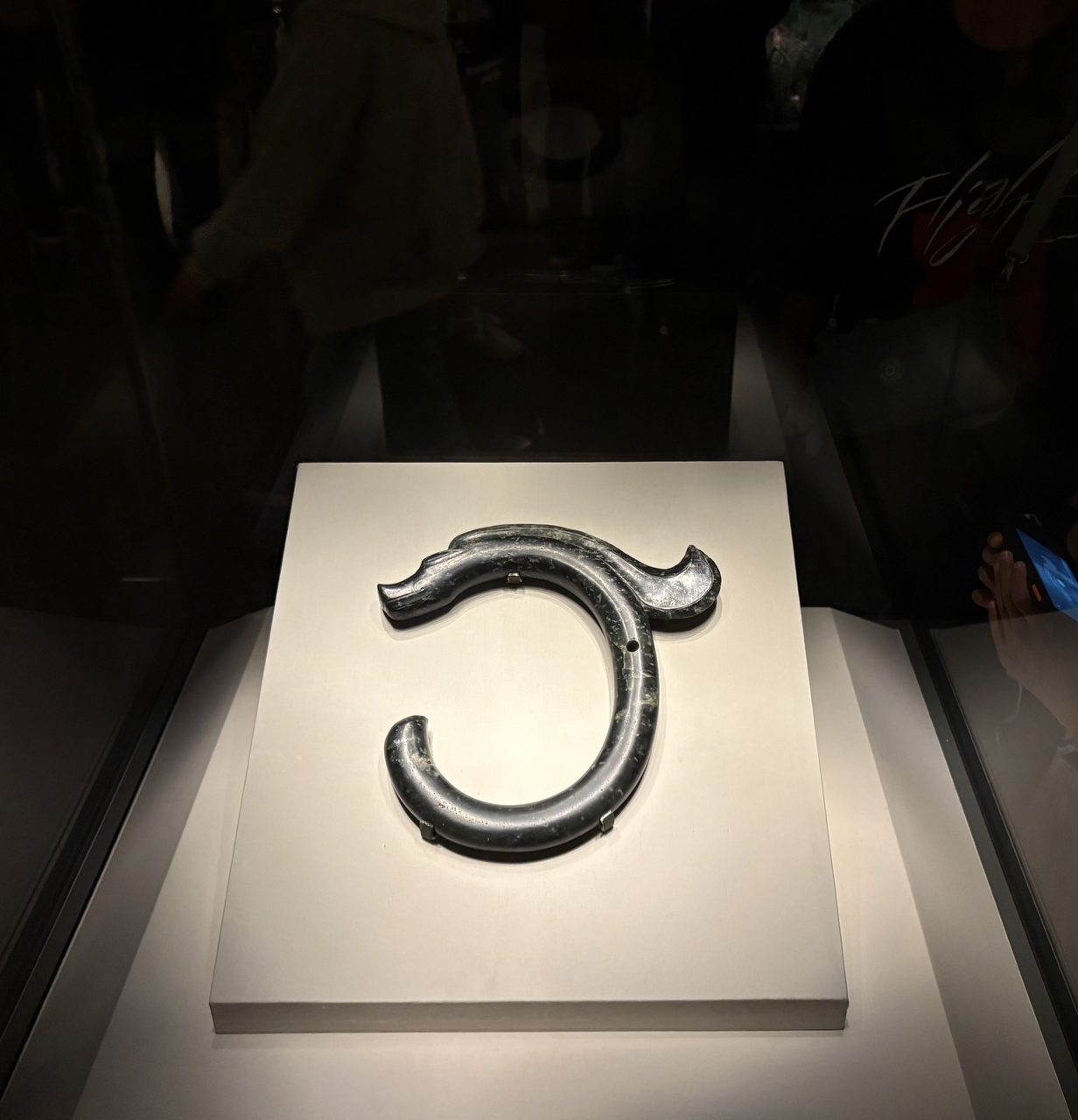 The C-shaped Hongshan jade dragon, a dark polished jade curved into a closed C with a snouted head
