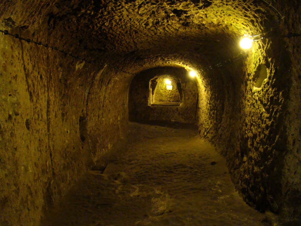 A carved tunnel descending between levels inside the Derinkuyu underground city in Cappadocia, Turkey