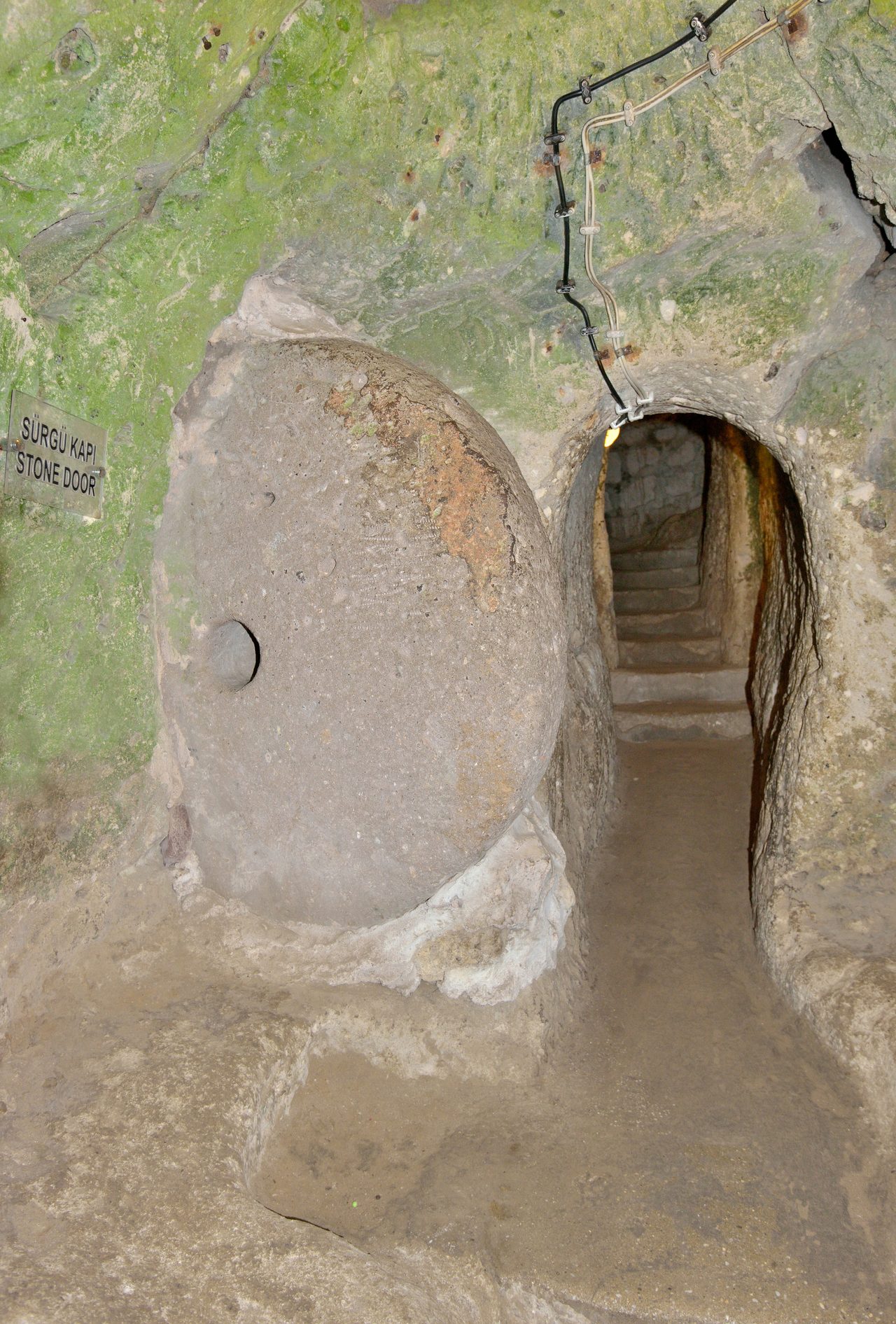 A large circular rolling stone door set into a tunnel wall at Derinkuyu underground city