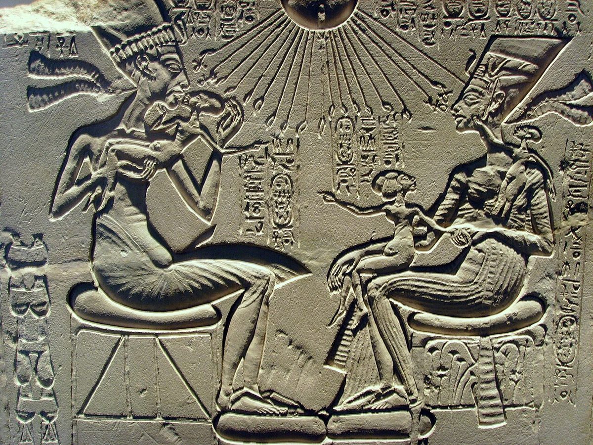 A carved relief of Akhenaten and Nefertiti with their children, the children shown with long backswept heads