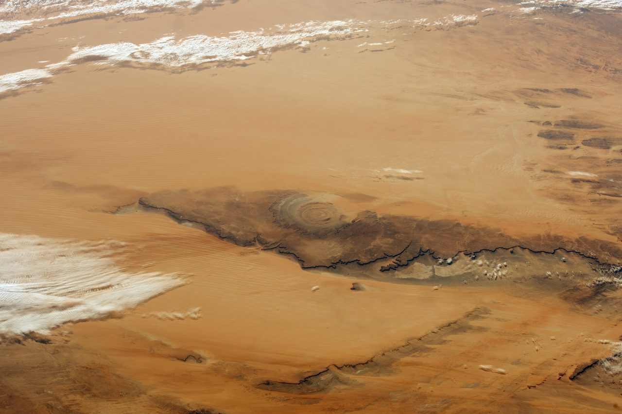 An orbital photograph of the Richat Structure in the Sahara, showing its full concentric-ring bullseye pattern from space