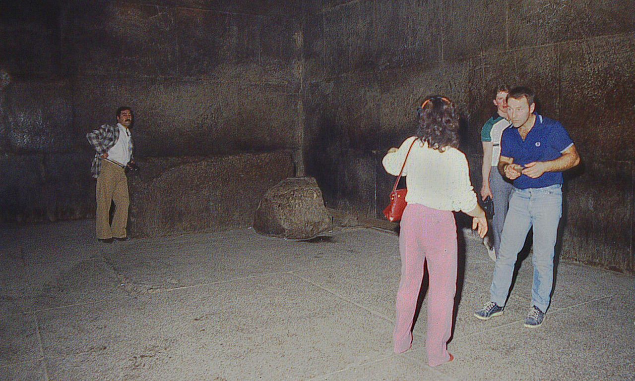 The bare red granite interior of the King's Chamber inside the Great Pyramid, with the lidless granite sarcophagus