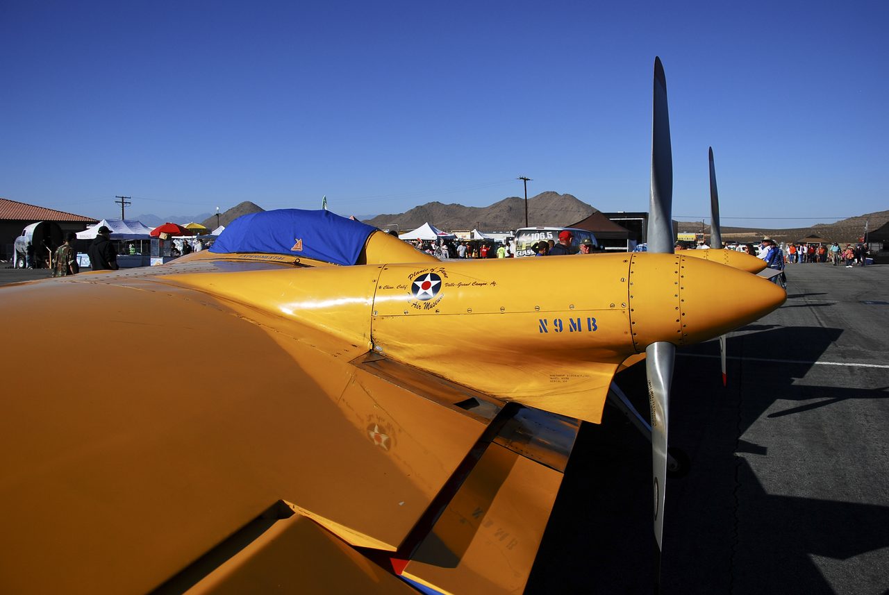 A preserved yellow Northrop N-9M flying wing on tarmac, seen along the wing toward the nose and propeller
