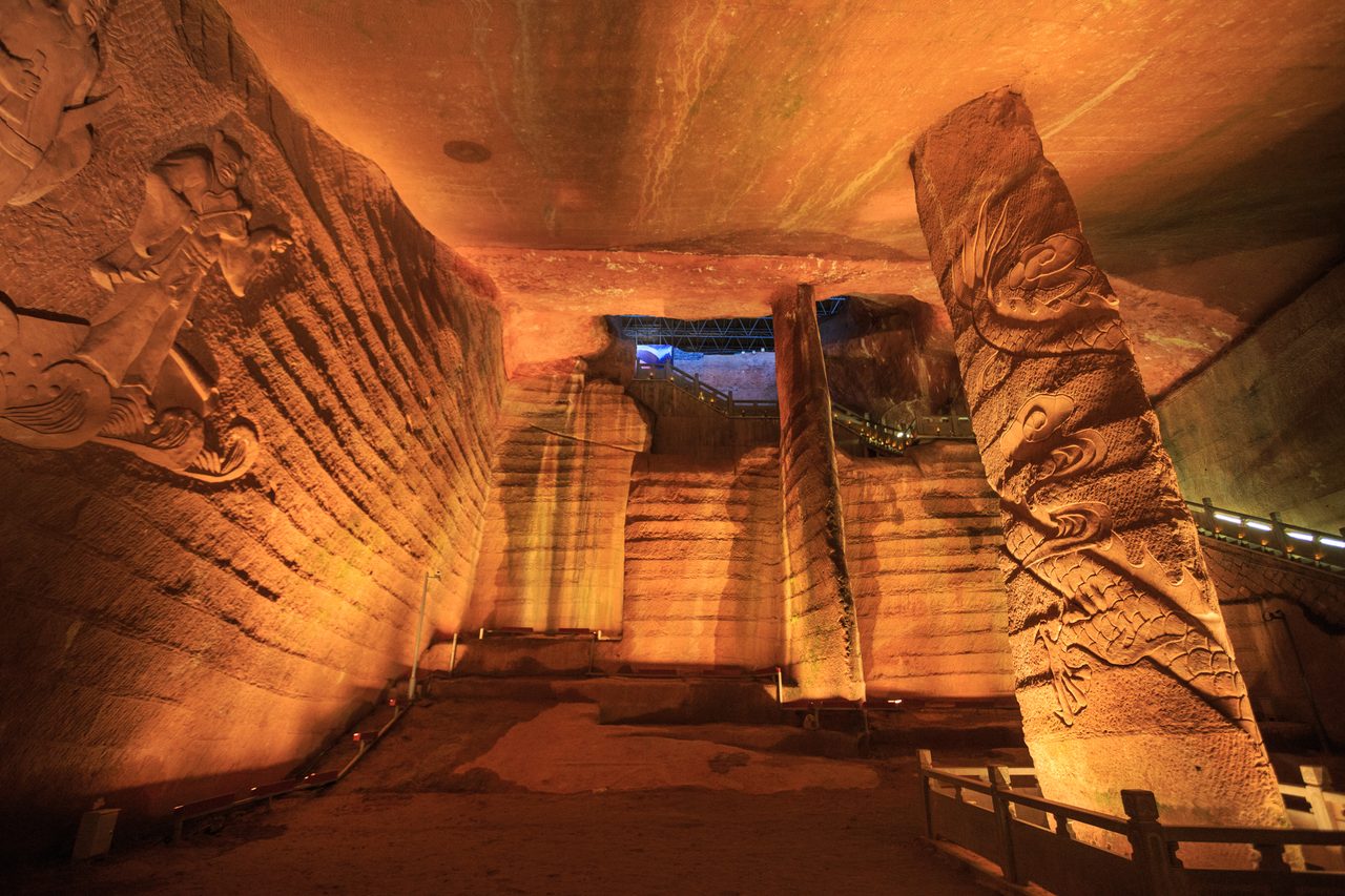 A wide chamber at the Longyou Caves showing two support pillars, prepared for public visitors as part of the site's tourist access