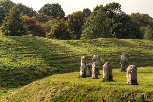 Part of the great stone circle at Avebury in Wiltshire, weathered standing stones spaced across open grassland
