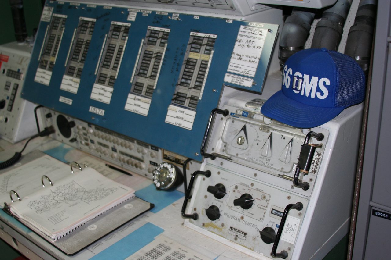 A preserved Minuteman launch control commander's console with a status panel, a launch control keyswitch and an open checklist binder