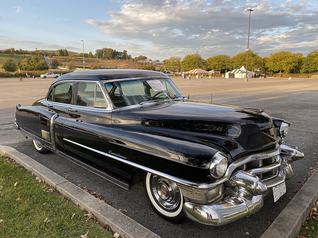 A black 1950s Cadillac sedan parked on a period street