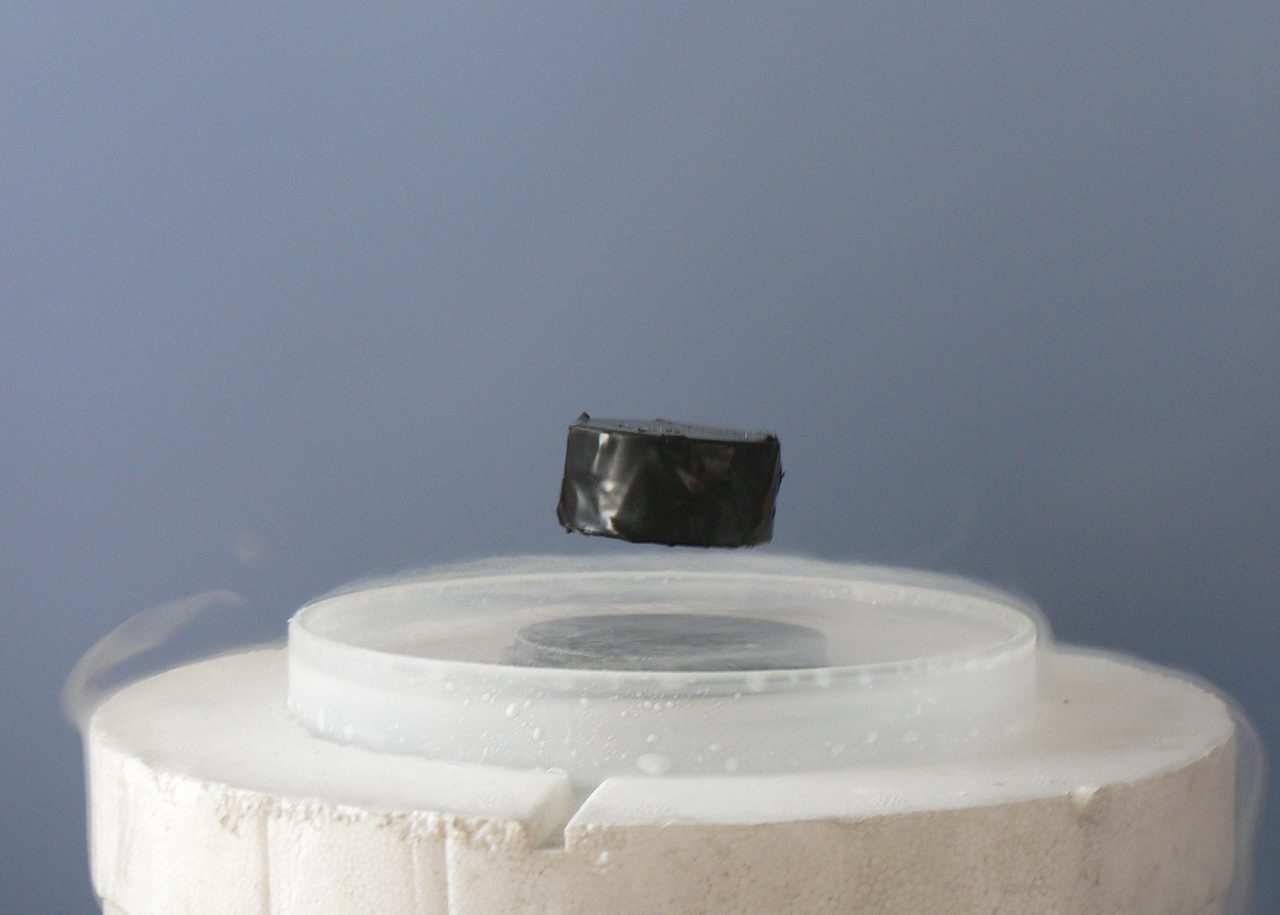A magnet levitating above a superconductor cooled with liquid nitrogen, demonstrating the Meissner effect.