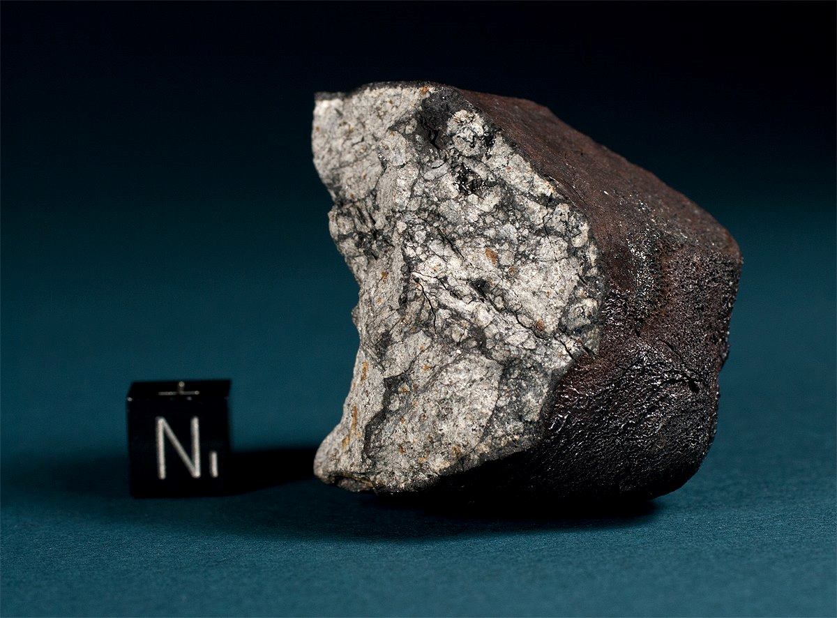 A recovered fragment of the Chelyabinsk meteorite, with a 1-centimeter scale cube for size reference