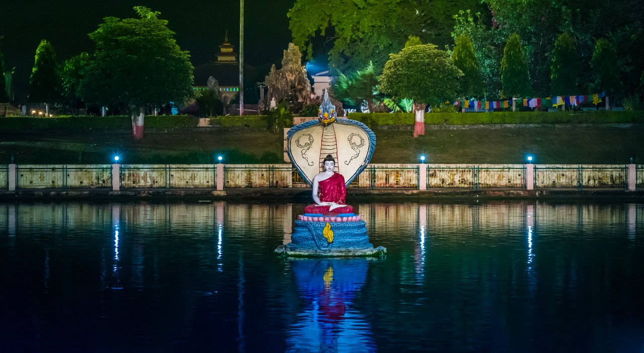 Stone sculpture of the naga king Mucalinda sheltering the meditating Buddha, Mucalinda Lake, Bodh Gaya, India