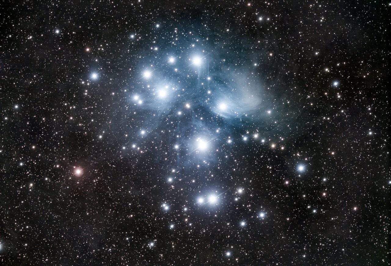 The Pleiades open star cluster, Messier 45, the bright blue stars of the Seven Sisters wrapped in faint reflection nebulosity