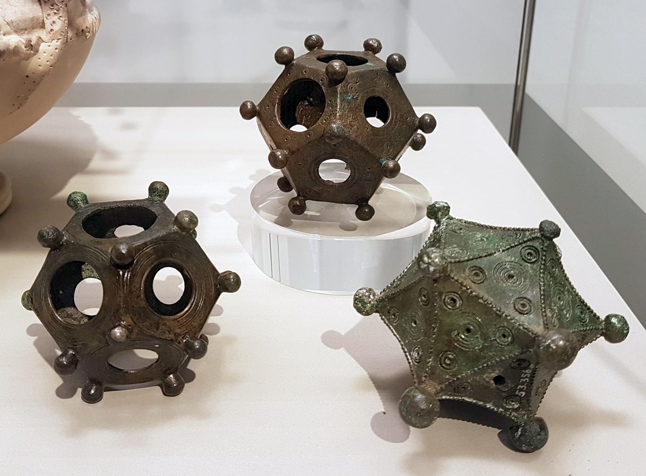 Two bronze Roman dodecahedra and the sole known bronze icosahedron, displayed together at the Rheinisches Landesmuseum Bonn