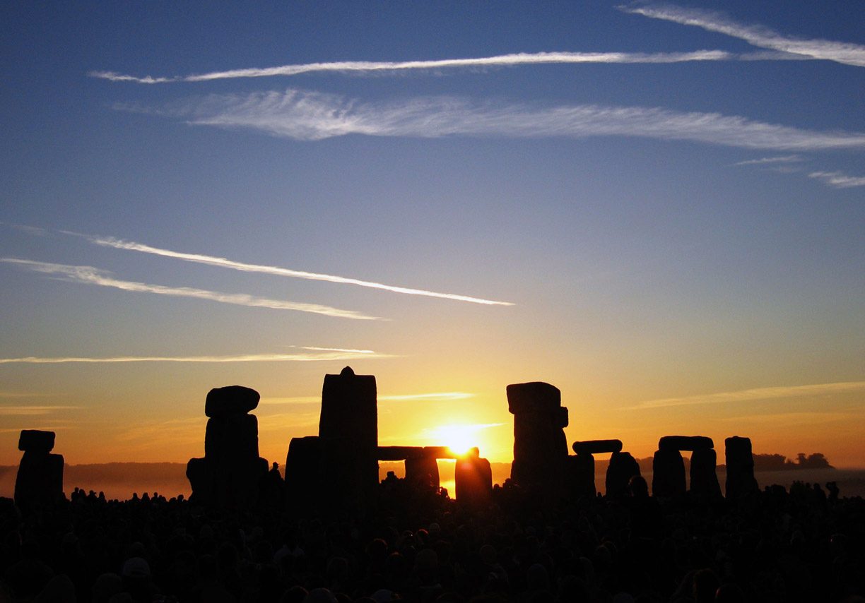The sun rising over the stones of Stonehenge on the morning of the summer solstice