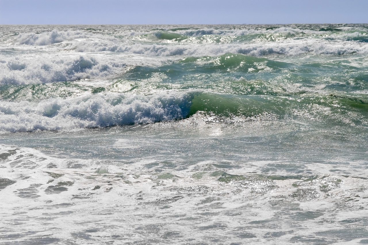 Ocean waves rolling in open water toward a beach, with no land features or people in the frame