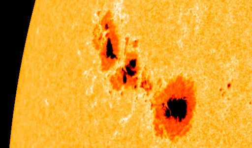A NASA photograph of a large dark sunspot group on the face of the sun.